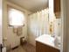Bathroom with a window, shower curtain, and neutral colored tile flooring at 2657 Mars Hill St, Indianapolis, IN 46241