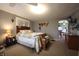 Comfortable bedroom with a quilt-covered bed, bench seating, and a view into the kitchen at 2657 Mars Hill St, Indianapolis, IN 46241