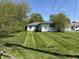View of the home's backyard with freshly cut grass and a white house at 2842 Sangster Ave, Indianapolis, IN 46218