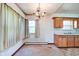 Dining area with vintage chandelier, window, and connection to the kitchen at 2842 Sangster Ave, Indianapolis, IN 46218