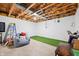 Unfinished basement featuring an indoor putting green, exposed ceiling, and ladder at 3165 Sycamore Dr, Columbus, IN 47203