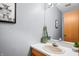Bathroom features a vanity with a single sink, a mirror, and light gray walls at 3165 Sycamore Dr, Columbus, IN 47203