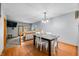 Open-concept dining area with wood floors, modern lighting fixture, and access to the living room at 3165 Sycamore Dr, Columbus, IN 47203