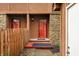 A red front door provides entry to the townhome with adjacent stone accents at 3165 Sycamore Dr, Columbus, IN 47203