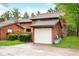 This two-story home features a detached one-car garage with a white door at 3165 Sycamore Dr, Columbus, IN 47203