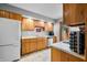 Traditional kitchen with wood cabinets, white appliances, and tile flooring at 3165 Sycamore Dr, Columbus, IN 47203