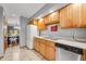 Traditional kitchen featuring wood cabinetry, stainless steel dishwasher, and bright tile flooring at 3165 Sycamore Dr, Columbus, IN 47203
