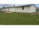 Backyard view showing a small deck, tidy landscaping, and a well maintained lawn at 3209 Pebblebrook Dr, Elwood, IN 46036