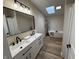 Bathroom with double sink vanity, modern fixtures, skylight, and soaking tub at 3209 Pebblebrook Dr, Elwood, IN 46036