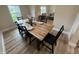 Dining room features wood table set for eight, light wood floors and large window at 3209 Pebblebrook Dr, Elwood, IN 46036