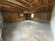 This garage is a large space with exposed rafters and natural lighting and a back entry door at 3209 Pebblebrook Dr, Elwood, IN 46036