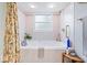 Inviting soaking tub with tile surround and a window for natural light at 3444 Briar Pl, Carmel, IN 46033