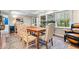 Dining area with a wooden table, adjacent wet bar, large windows, and a rustic-style area rug at 3444 Briar Pl, Carmel, IN 46033