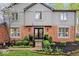 Attractive brick home showcasing a well-maintained front yard with mature landscaping, a charming flag, and updated black doors at 3444 Briar Pl, Carmel, IN 46033