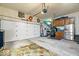 Spacious garage with overhead storage, stainless steel fridge, and access door at 3444 Briar Pl, Carmel, IN 46033