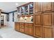 Elegant kitchen with granite countertops, wooden cabinets, glass display cases, and stainless-steel appliances at 3444 Briar Pl, Carmel, IN 46033