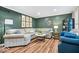 Stylish living room with hardwood floors, neutral sectional sofa, designer mirror, and blue accent chairs at 3444 Briar Pl, Carmel, IN 46033