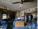 Living room showcases cluttered furnishings and tired wallpaper, indicating needed improvements at 3602 E 22Nd St, Indianapolis, IN 46218