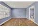 Blue painted bedroom with hardwood floors and natural light from the window, creating a serene and inviting atmosphere at 3652 Newberry Rd, Plainfield, IN 46168