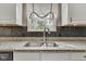 Close up on modern sink with granite countertop, stainless faucet, and tiled backsplash at 3652 Newberry Rd, Plainfield, IN 46168