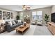 Bright living room with a gray sofa, natural light, and a ceiling fan at 3652 Newberry Rd, Plainfield, IN 46168