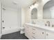 Updated bathroom with dual vanity, designer wallpaper, tile floors, quartz countertops, and shower/tub combo at 3845 Cornelius Ave, Indianapolis, IN 46208