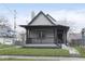 Charming gray home featuring a covered front porch and well-maintained lawn at 3845 Cornelius Ave, Indianapolis, IN 46208