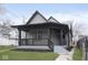 Charming home featuring a covered front porch with black accents and landscaped yard at 3845 Cornelius Ave, Indianapolis, IN 46208
