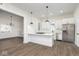 Bright kitchen features white cabinets, quartz countertops, undermount sink, stainless steel appliances and wood-look vinyl flooring at 3845 Cornelius Ave, Indianapolis, IN 46208