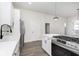 Bright kitchen features white cabinets, quartz countertops, undermount sink, stainless steel appliances and wood-look vinyl flooring at 3845 Cornelius Ave, Indianapolis, IN 46208