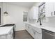 Bright kitchen features white cabinets, quartz countertops, undermount sink, stainless steel appliances and wood-look vinyl flooring at 3845 Cornelius Ave, Indianapolis, IN 46208