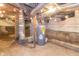 Unfinished basement with exposed pipes, hot water heater, and concrete foundation walls at 400 N Sycamore St, Martinsville, IN 46151
