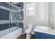Stylish bathroom features blue and gray tiled shower with glass doors, modern vanity, and neutral walls at 400 N Sycamore St, Martinsville, IN 46151