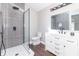 Modern bathroom showcasing a glass-enclosed shower with rainfall showerhead, dark fixtures, and a vanity at 400 N Sycamore St, Martinsville, IN 46151
