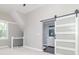 Bright bedroom featuring a modern sliding door leading to bathroom, and a view from the stairway at 400 N Sycamore St, Martinsville, IN 46151