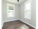 Bright bedroom features hardwood floors, two windows, and neutral paint, creating a welcoming and move-in ready space at 400 N Sycamore St, Martinsville, IN 46151