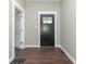 View of the entryway, featuring a black door with decorative glass, modern trim, and hardwood floors at 400 N Sycamore St, Martinsville, IN 46151