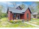 Charming renovated bungalow with red siding, grey roof, a quaint porch, and fresh landscaping at 400 N Sycamore St, Martinsville, IN 46151