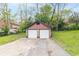 Detached two-car garage with brick and red siding and two white garage doors at 400 N Sycamore St, Martinsville, IN 46151