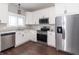 Modern kitchen with white cabinets, stainless steel appliances, granite countertops, and hardwood floors at 400 N Sycamore St, Martinsville, IN 46151