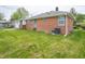View of the back of the home with a brick exterior, large backyard, and mature trees at 4029 N Euclid Ave, Indianapolis, IN 46226