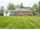 Lush backyard showing the brick home exterior with two entry doors and a pristine lawn at 4029 N Euclid Ave, Indianapolis, IN 46226