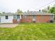 Home's backyard features a brick exterior, manicured lawn, and an inviting patio area at 4029 N Euclid Ave, Indianapolis, IN 46226