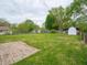 Large backyard with a patio, lawn, wooden fence, trees, and a white storage shed at 4029 N Euclid Ave, Indianapolis, IN 46226