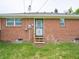 Exterior shot showing back entrance with brick facade and stairs, plus green lawn at 4029 N Euclid Ave, Indianapolis, IN 46226