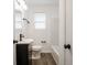 Bathroom featuring a dark vanity, modern fixtures, a white toilet, and a shower/tub at 4029 N Euclid Ave, Indianapolis, IN 46226