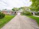 Classic brick ranch-style home with a long driveway, garage, and meticulously kept lawn at 4029 N Euclid Ave, Indianapolis, IN 46226