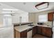 Cozy kitchen featuring tile countertops and a sink, adjacent to a bright living room at 4107 Zinfandel Way, Indianapolis, IN 46254