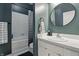 Well-lit bathroom featuring a sleek vanity, round mirror, and shower with a striped curtain at 430 N Park Ave # 103, Indianapolis, IN 46202