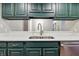 Kitchen featuring sleek counters, stainless steel appliances, and green cabinets at 430 N Park Ave # 103, Indianapolis, IN 46202